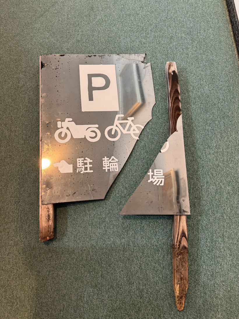 割れた駐輪場の看板